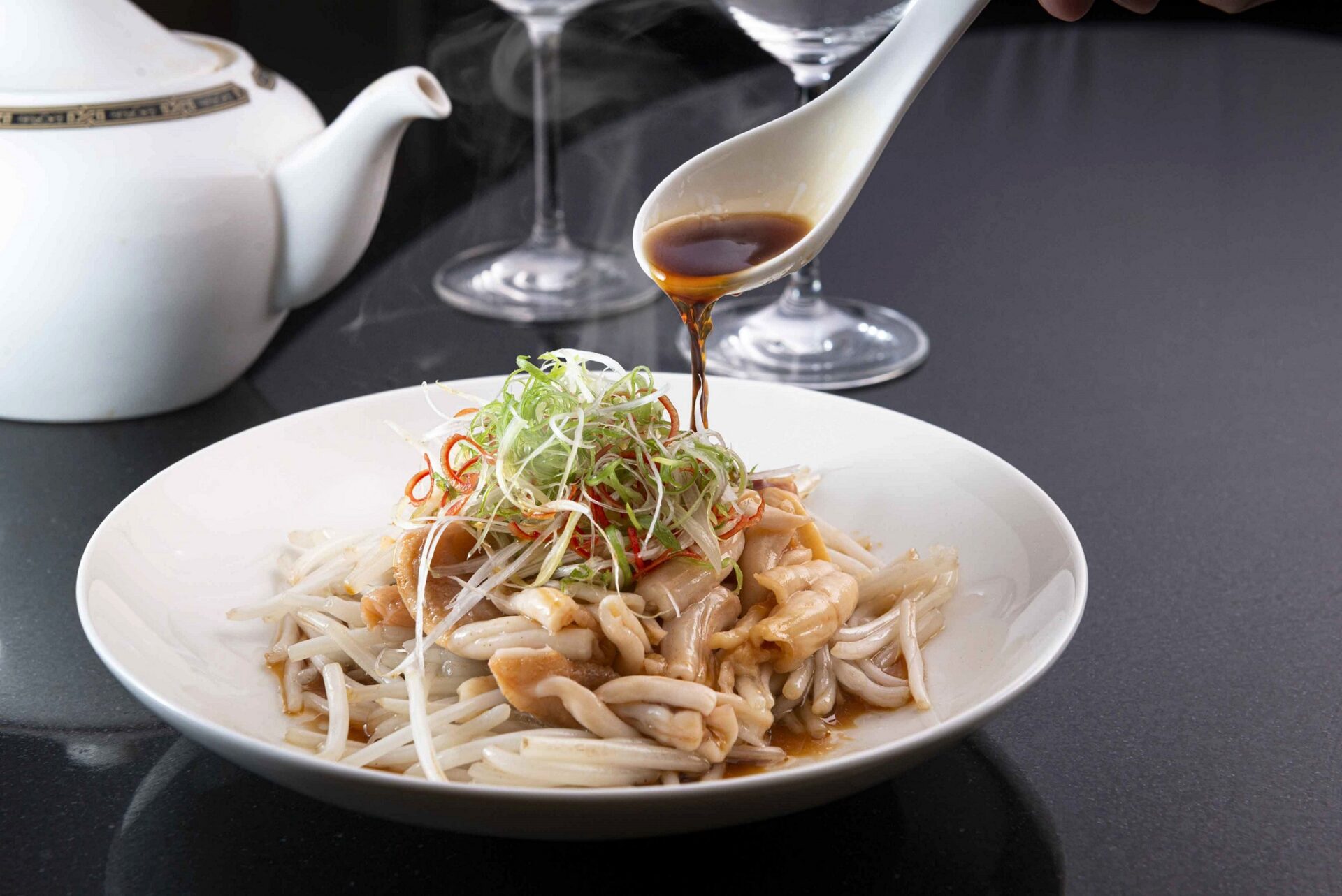 2023名人坊春季菜「蔥油灼加拿大桂花蚌」採用滋陰補腎的上品食材桂花蚌，口感爽脆彈牙，搭配銀芽與主廚特調醬汁，令人回味無窮。