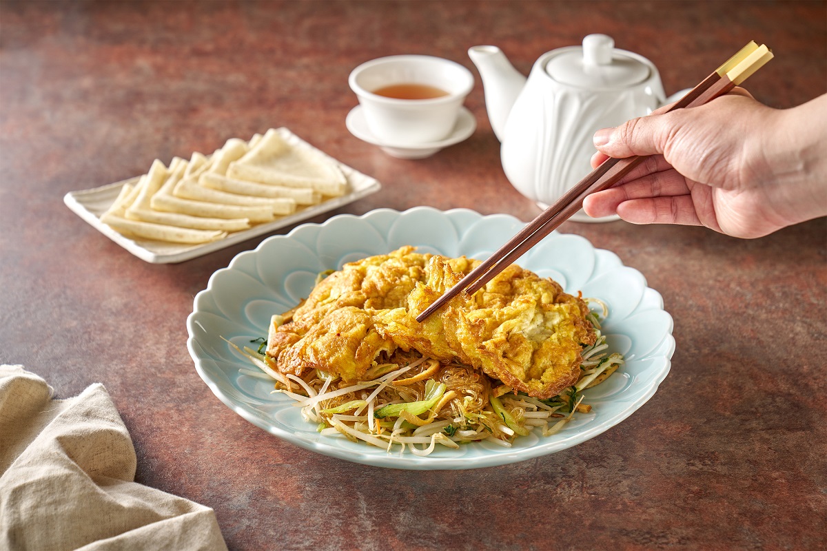 合菜戴帽又稱為金銀滿堂，盛盤後蓋上香氣十足的金黃烘蛋，除了可以傳統方式直接品饌，本次粵亮特別推出以全麥餅皮包裹的方式，更體現眷村老味道。(圖 六福旅遊集團提供)