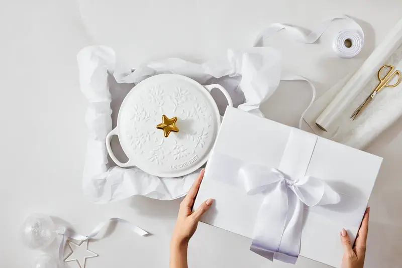 廣受喜愛的le Creuset琺瑯鑄鐵圓鍋，巧妙地將冬季森林中枝葉舒展的景致，以立體浮雕之姿展現於鍋蓋設計中；主打棉花白色系搭配金色星型蓋頭，宛如特意設置在聖誕樹最高處的閃