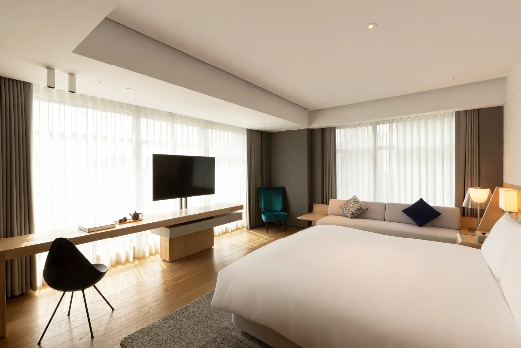 高雄然一酒店 空間設計取材北美實木與安格拉灰大理石，融合自然紋理與溫潤色系，如同回歸山海懷抱的沉靜儀式。 © The Amnis